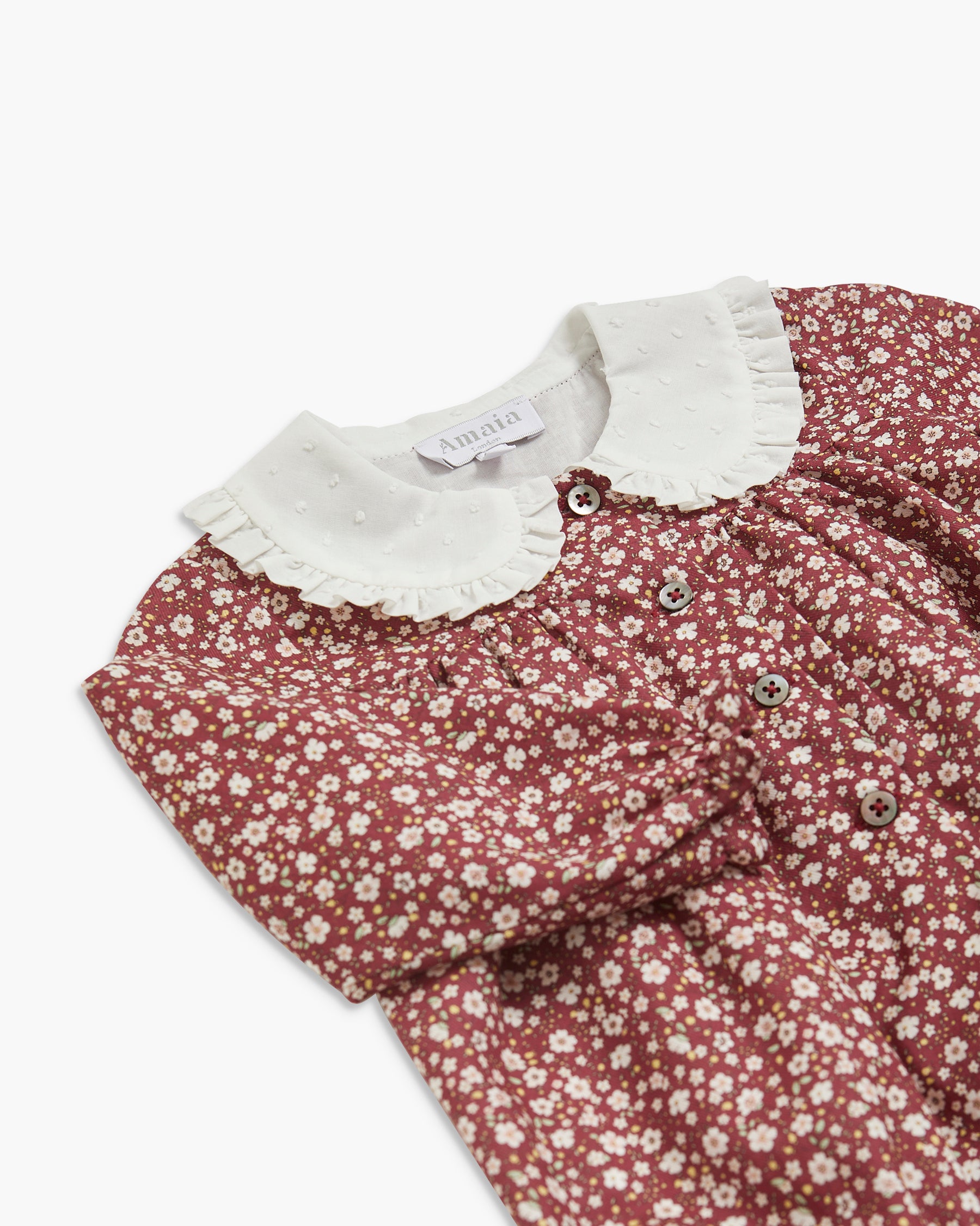 Floral baby dress with white collar on a white background