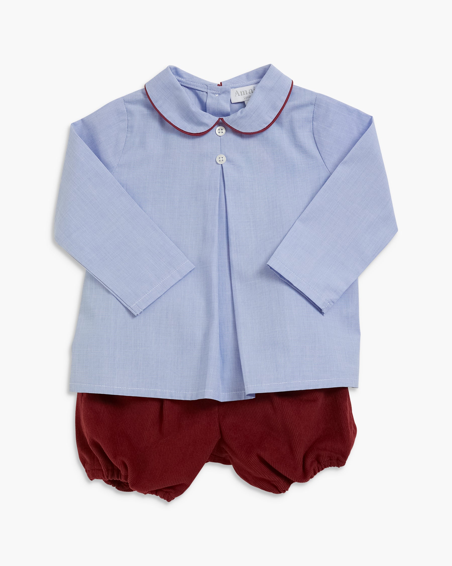 A baby boy's two-piece outfit featuring a light blue long-sleeve button-down shirt with a dark red Peter Pan collar, paired with matching dark red bubble shorts, laid flat against a light gray background.