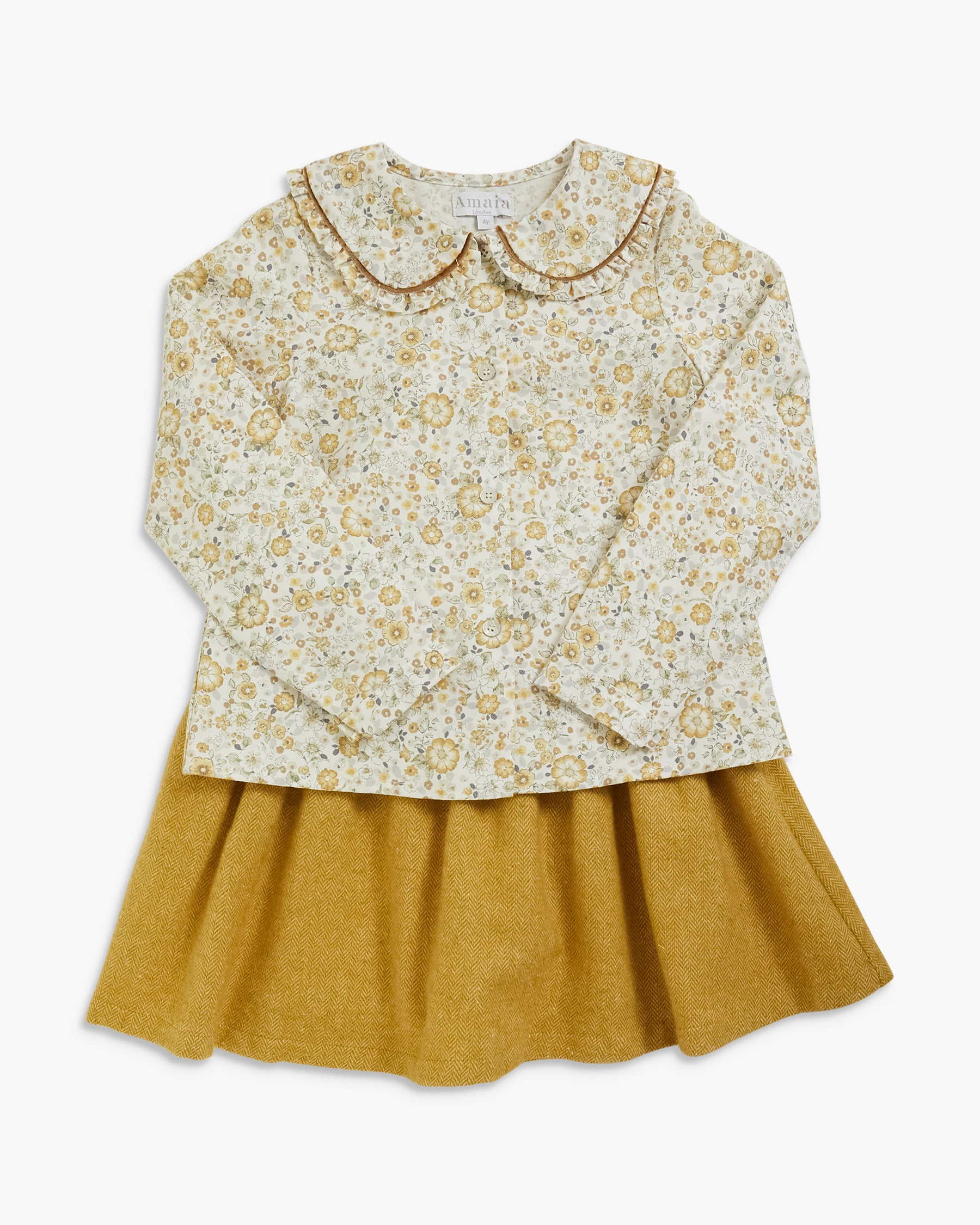 A children's long-sleeve top and skirt set featuring a cream-colored floral patterned blouse with a Peter Pan collar and a mustard yellow pleated skirt, shown flat on a light gray background.