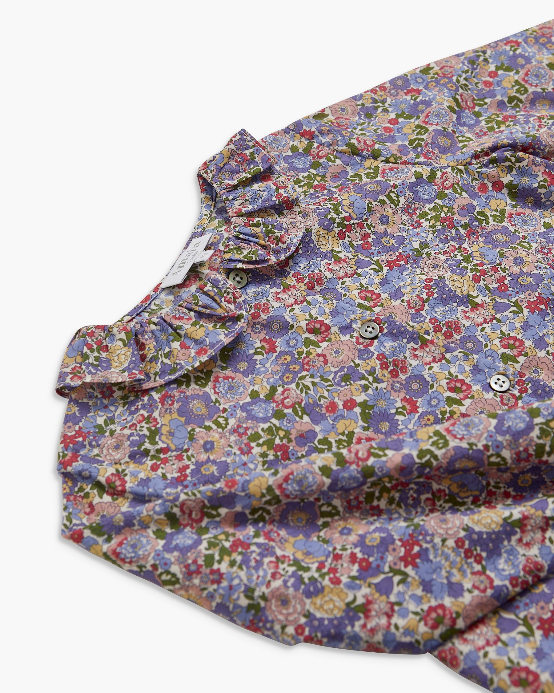 Floral patterned shirt with ruffled collar on a white background