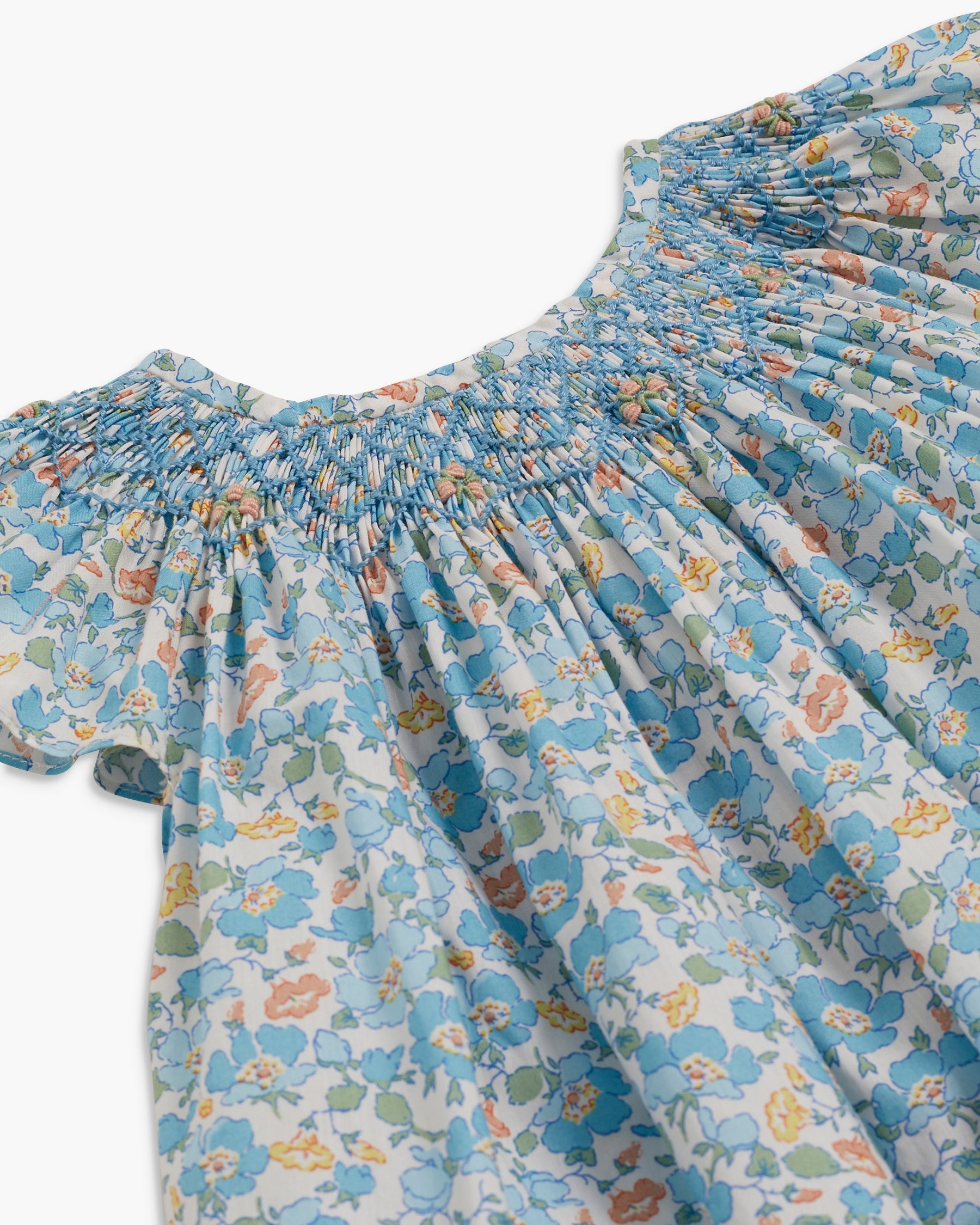 Floral dress with smocked neckline on a white background