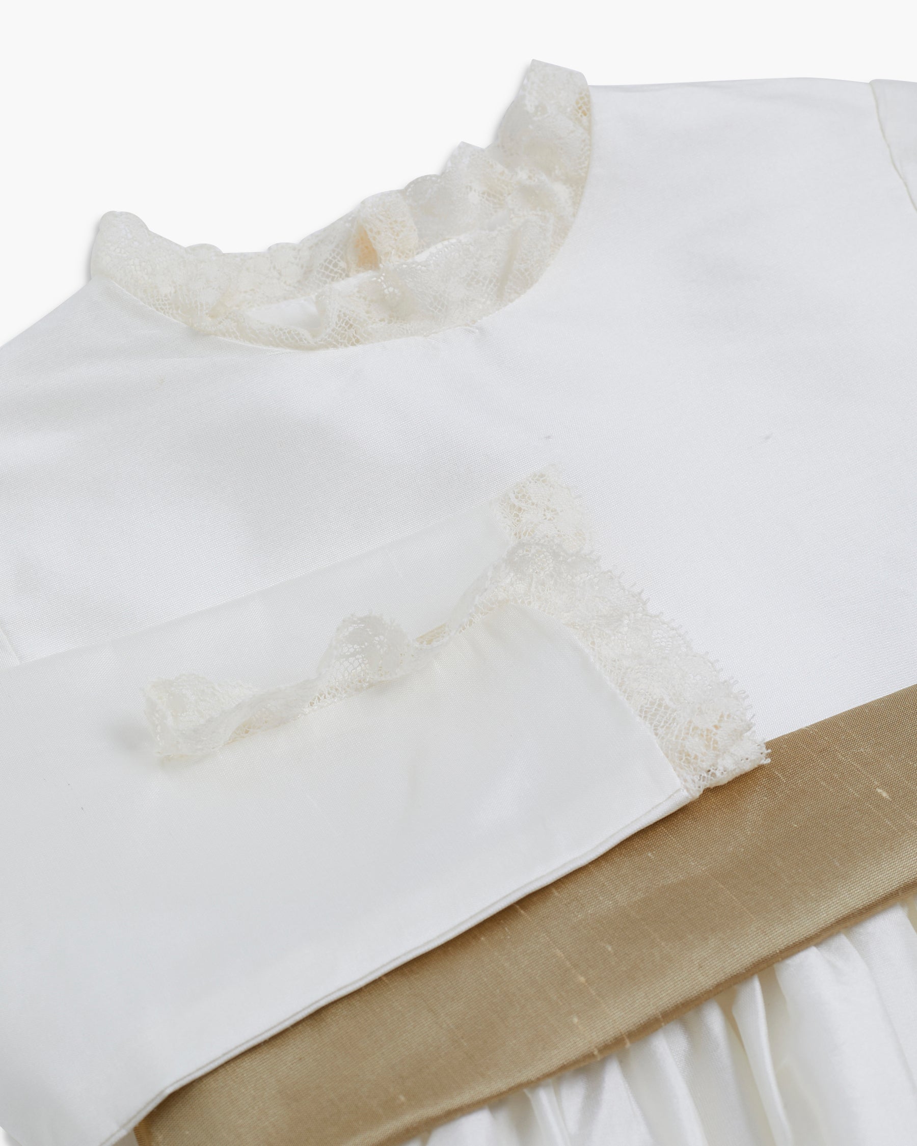 Close-up of a white dress with lace details on a white background