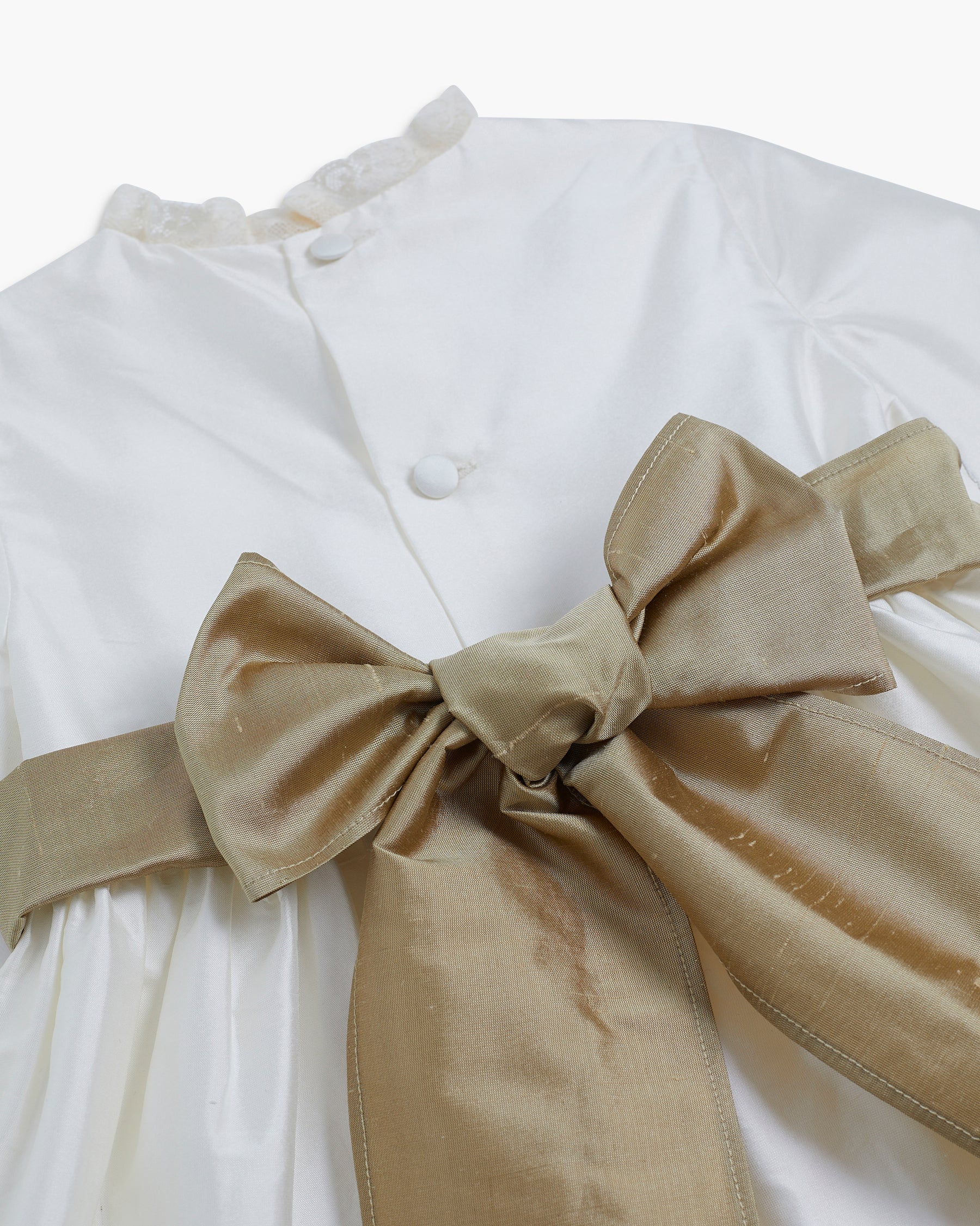 White dress with a large beige bow on a white background