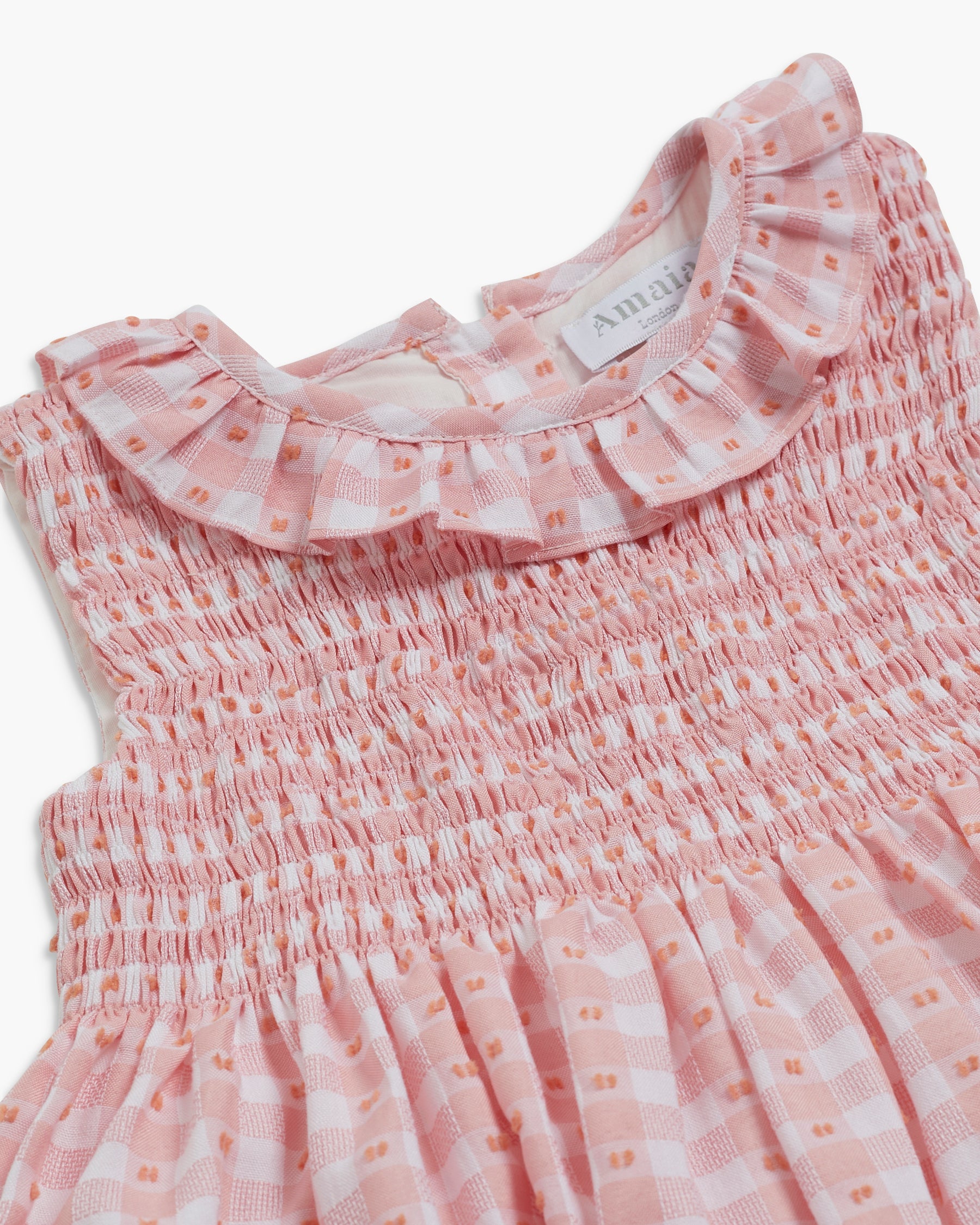 Pink checkered dress with ruffled collar on a white background