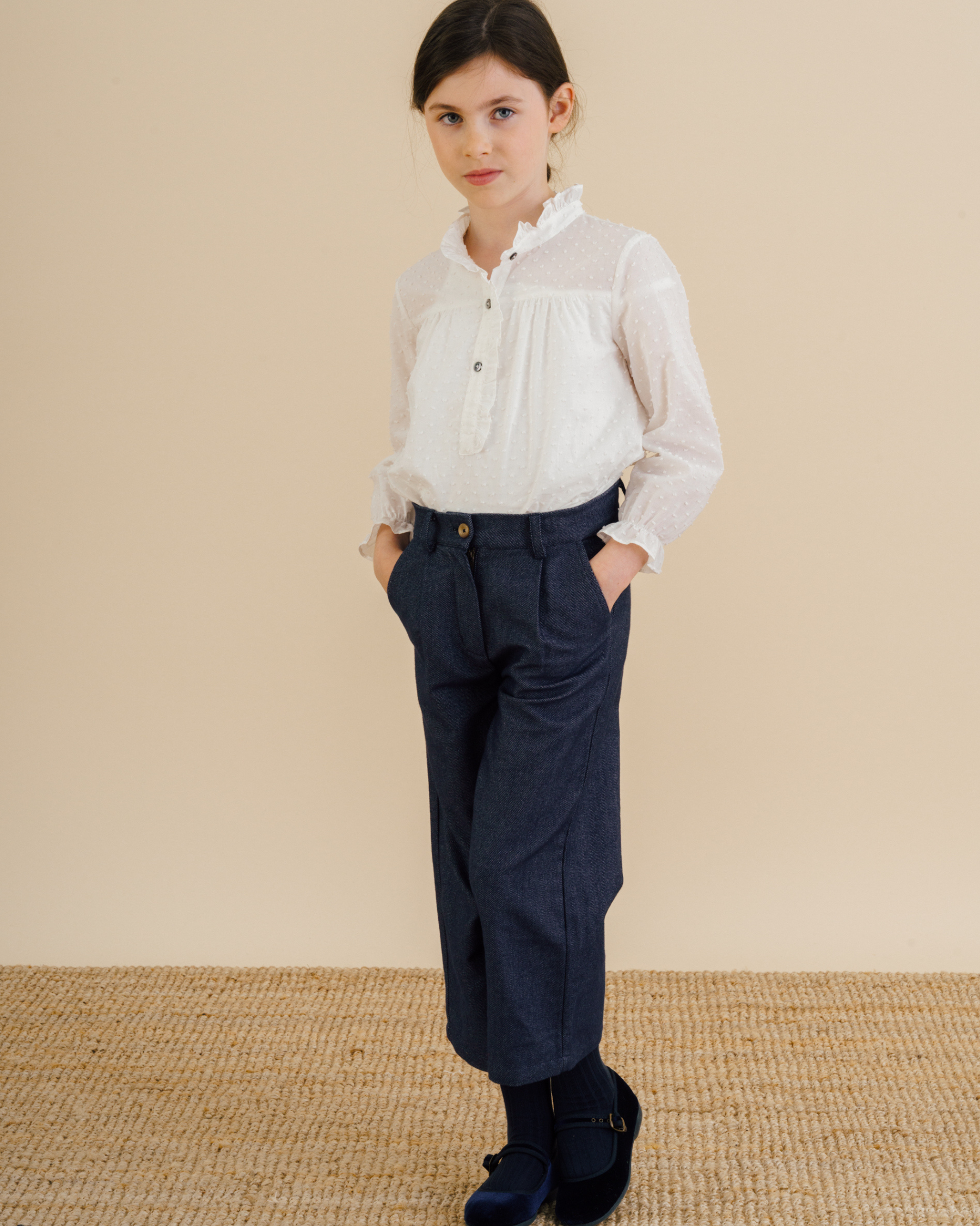 Girl wearing trousers in soft navy twill fabric with a white blouse