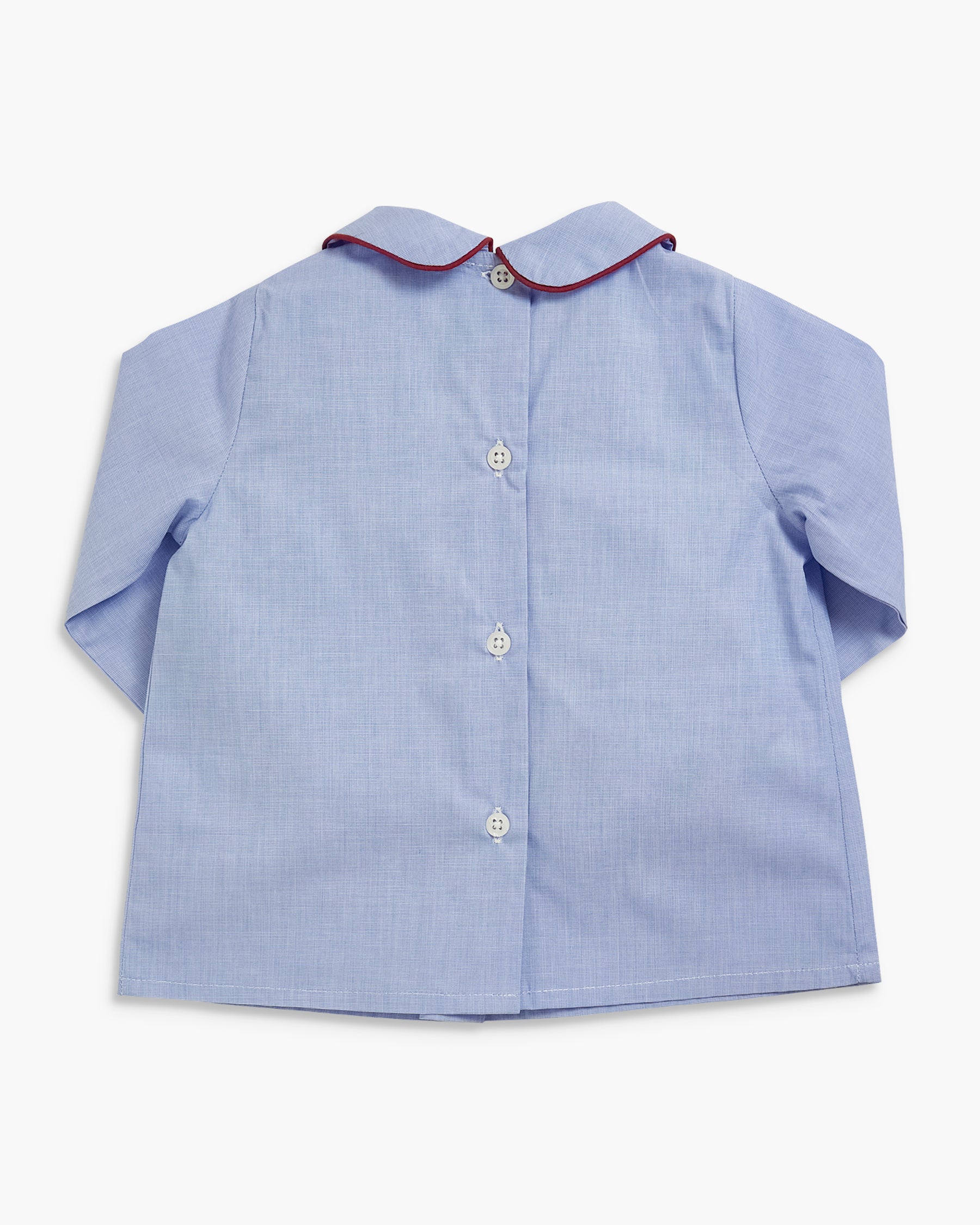 A light blue long-sleeve button-up shirt for a child, featuring a Peter Pan collar with a thin red piping trim and white buttons.