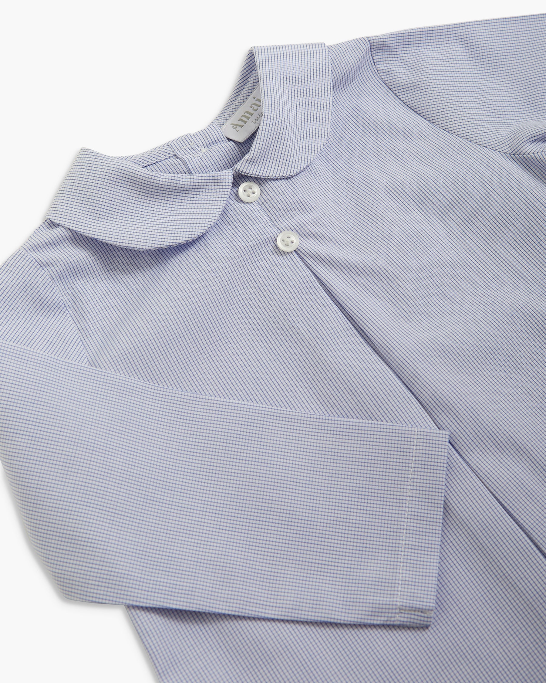 A close-up of a light blue and white micro-striped long-sleeve shirt with a Peter Pan collar and white buttons, laid flat on a white background.