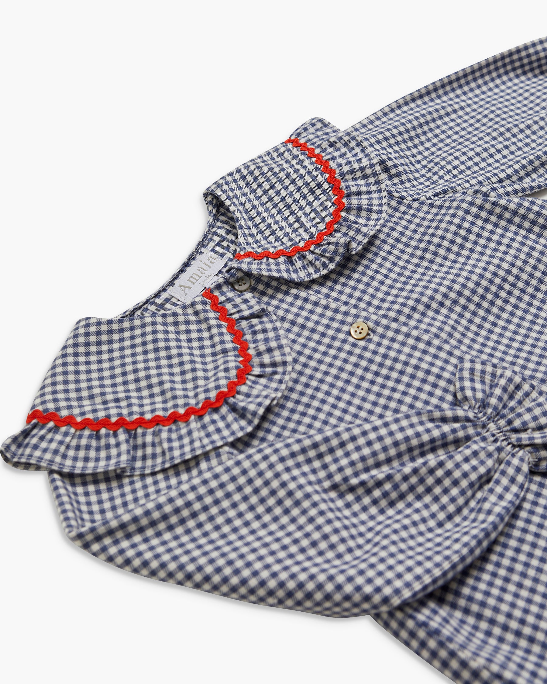 Blue and white checkered shirt with red trim on a white background