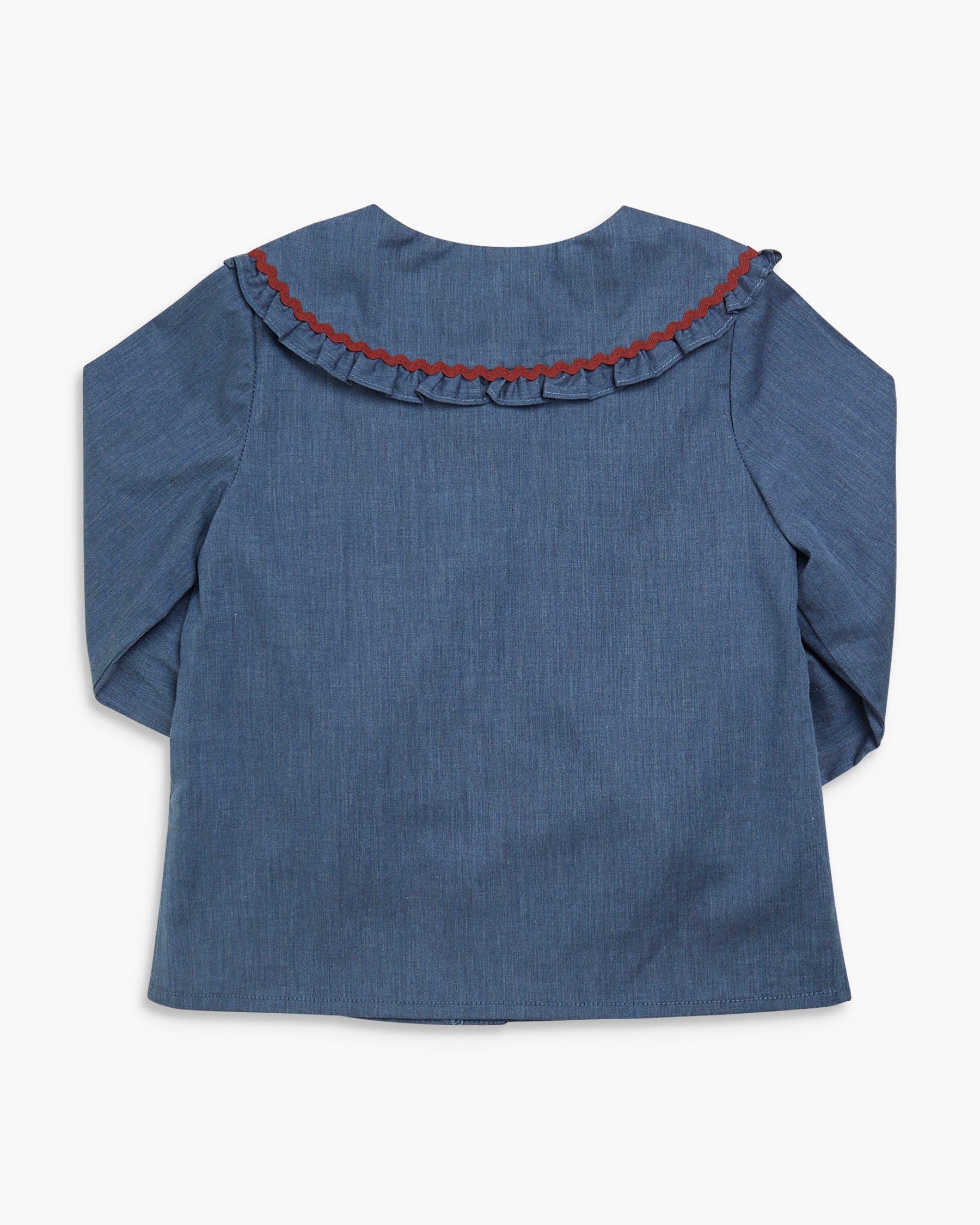 Blue denim blouse with red trim on a white background
