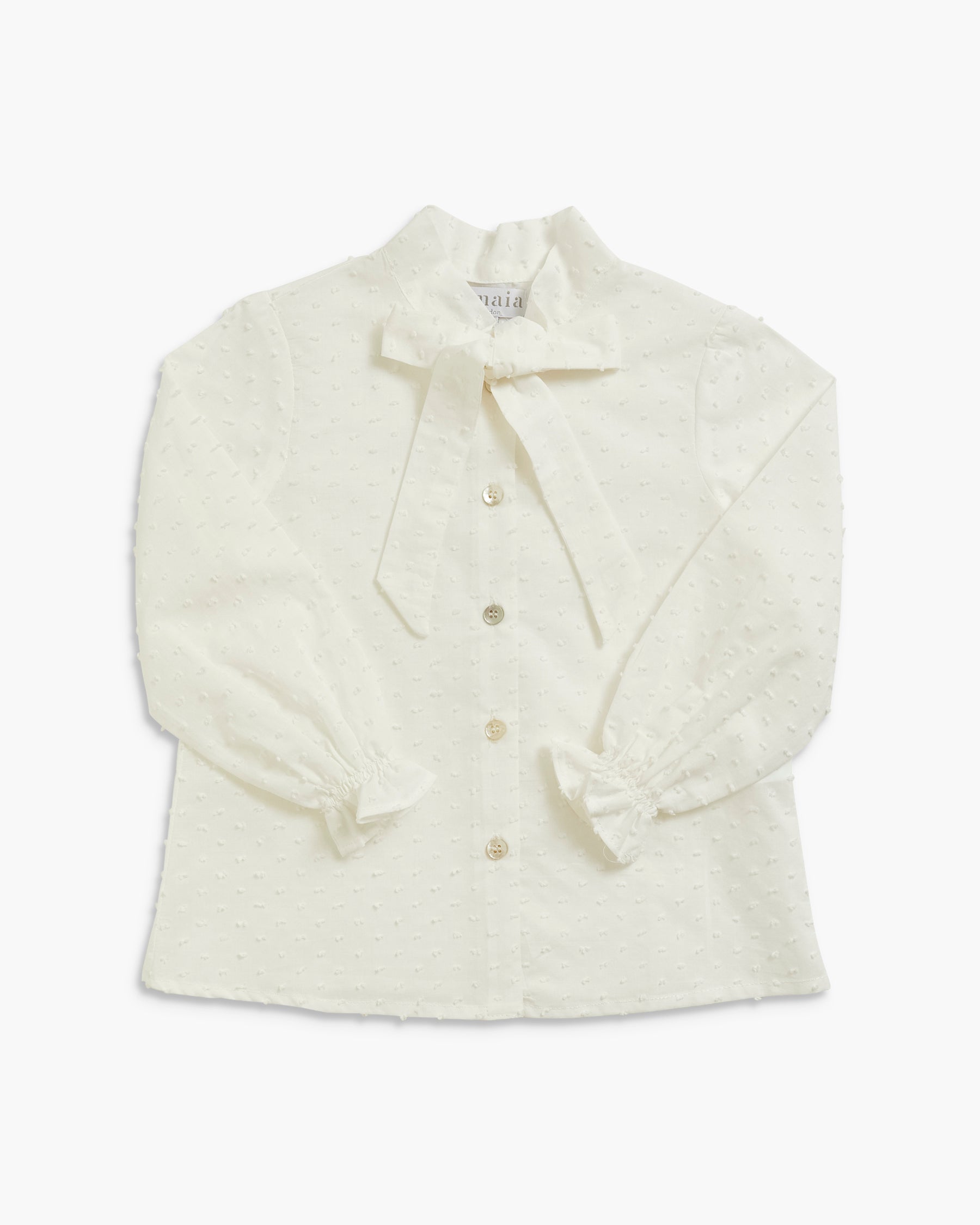 An off-white textured long-sleeve blouse with a large bow at the collar, buttoned front, and ruffled cuffs, shown flat on a white background.