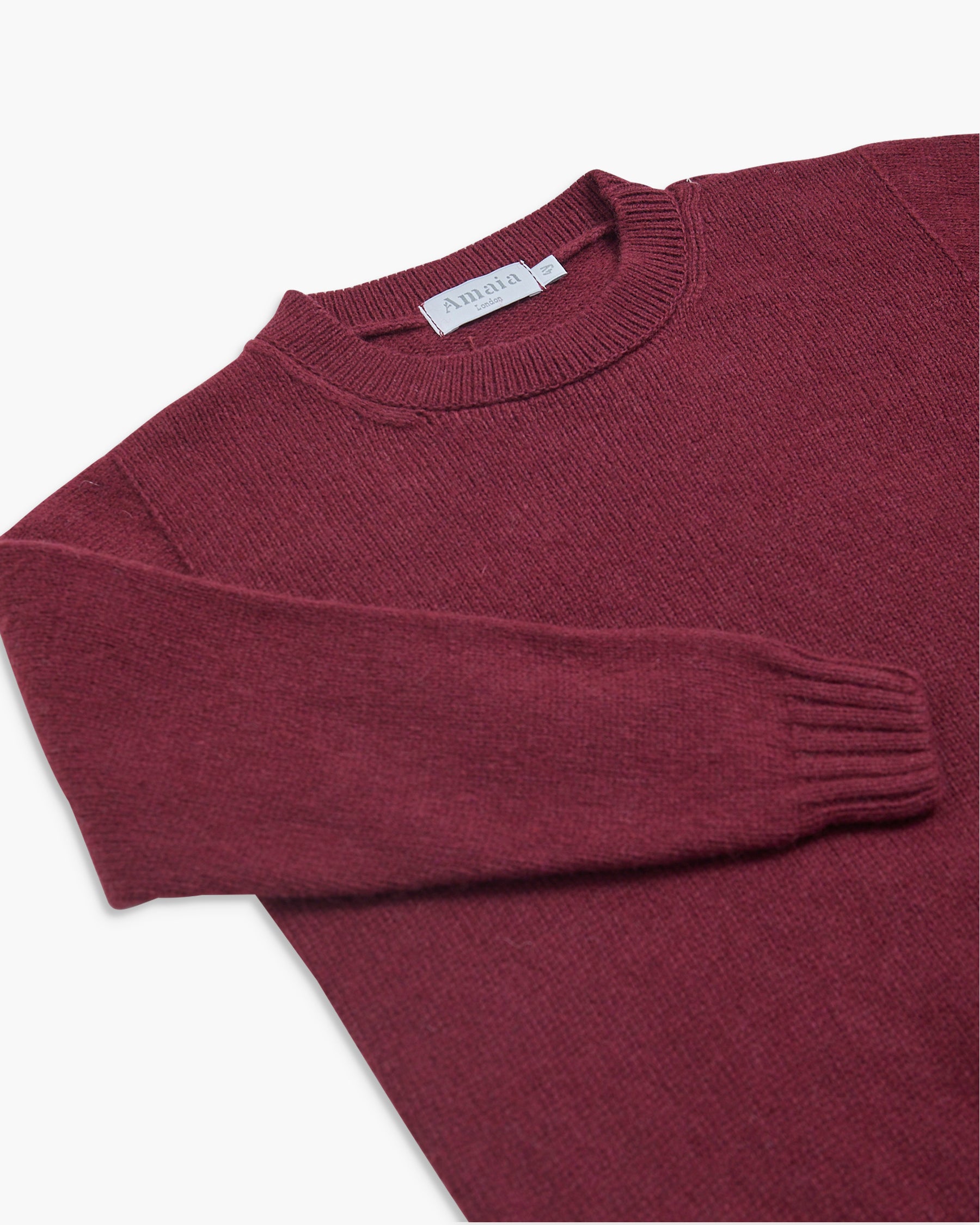 Maroon sweater with a brand label on a white background