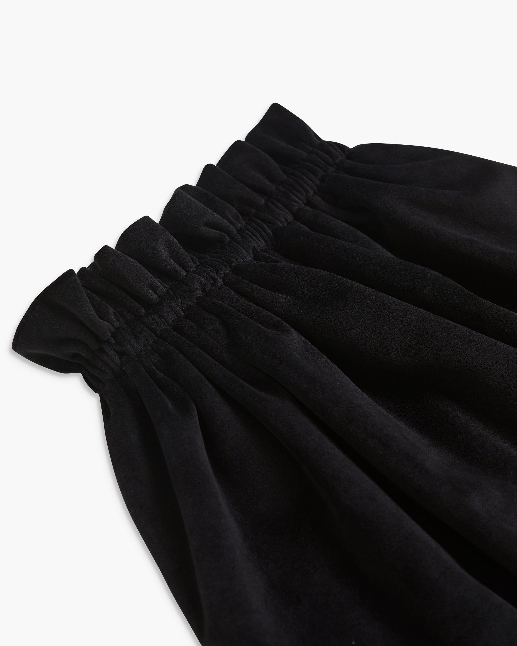 Close-up of black pants with a white background