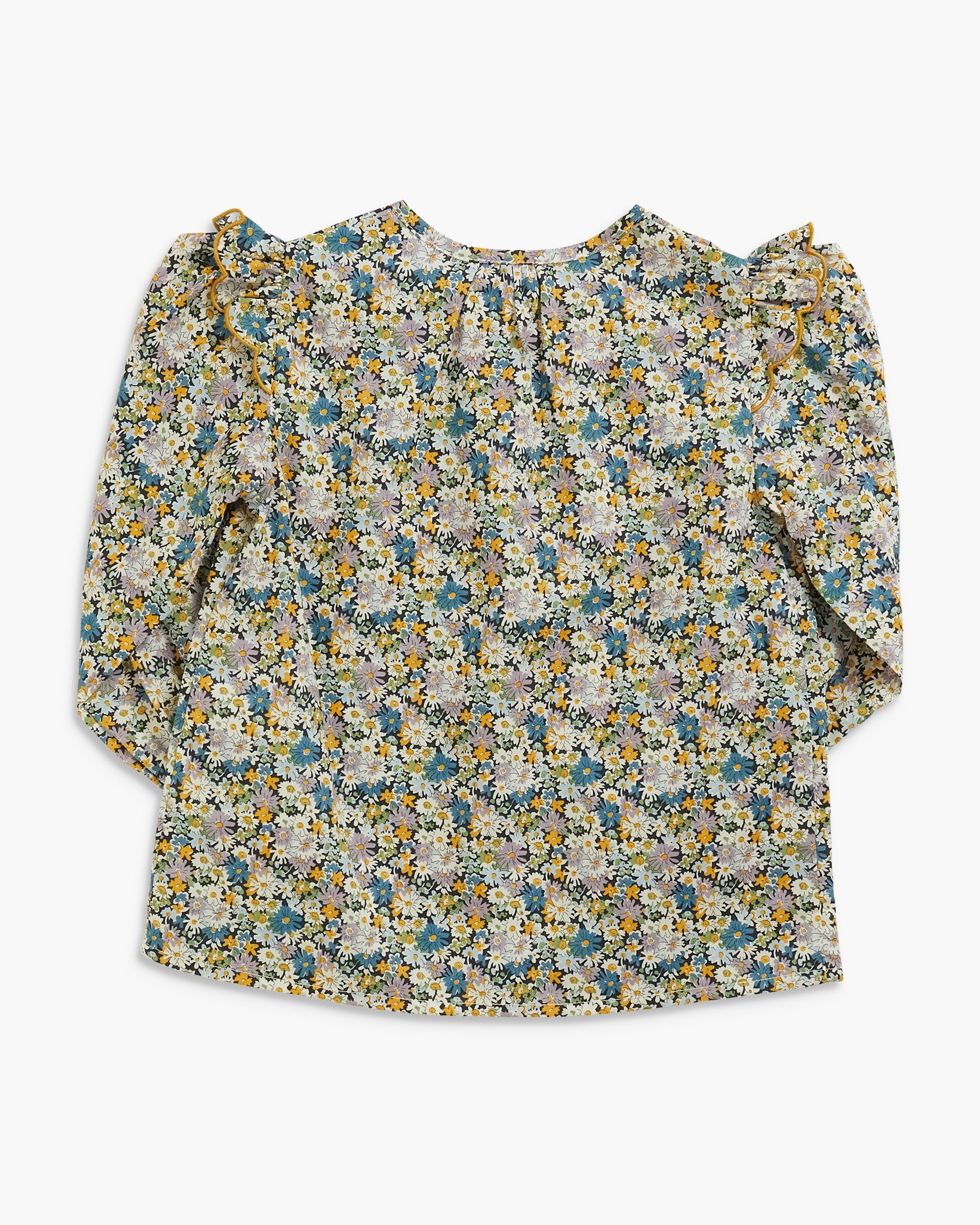 A long-sleeve blouse with a dense floral print in muted blue, yellow, and cream tones, featuring ruffled shoulders, laid flat against a light gray background.