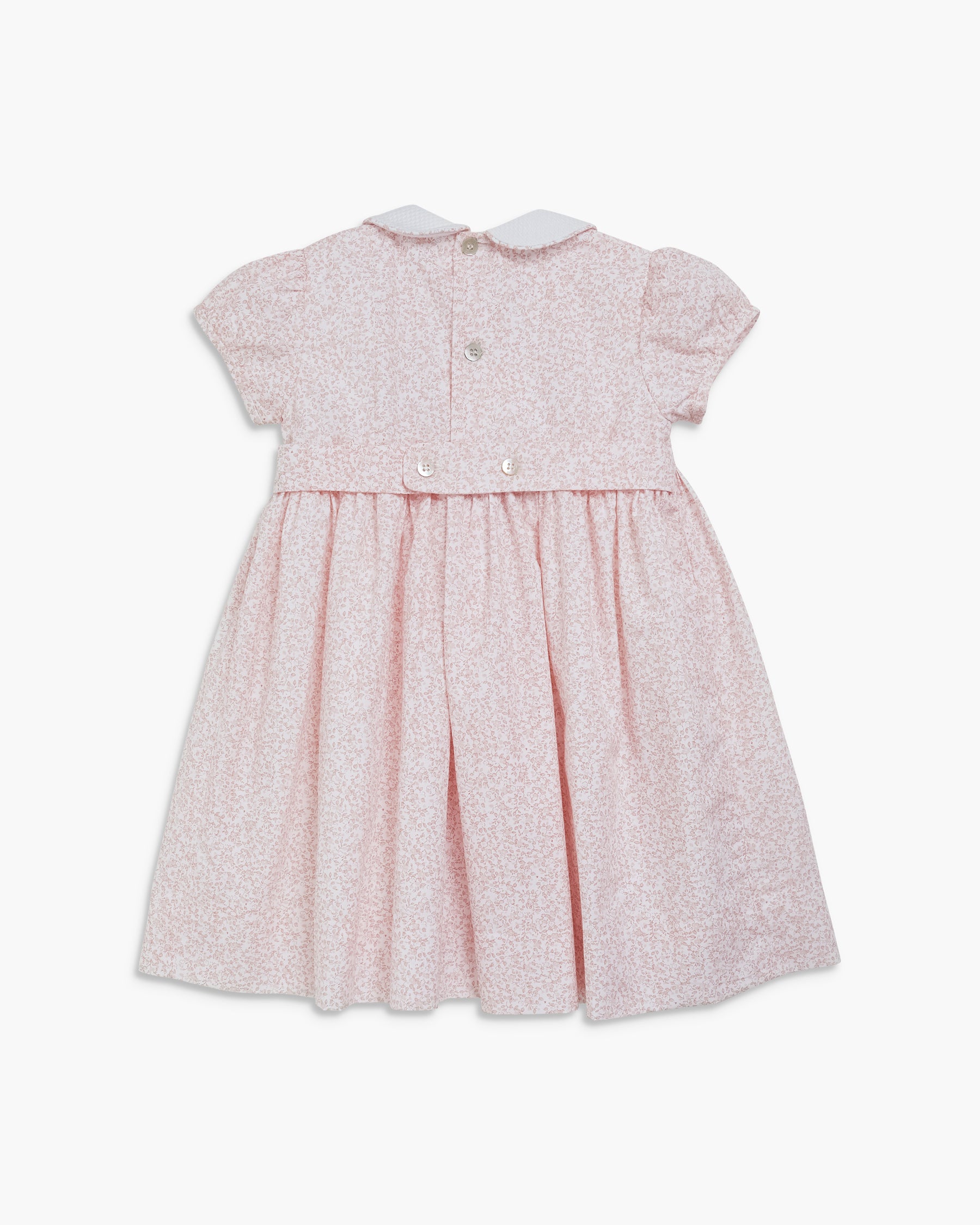 Pink dress with white pattern on a white background