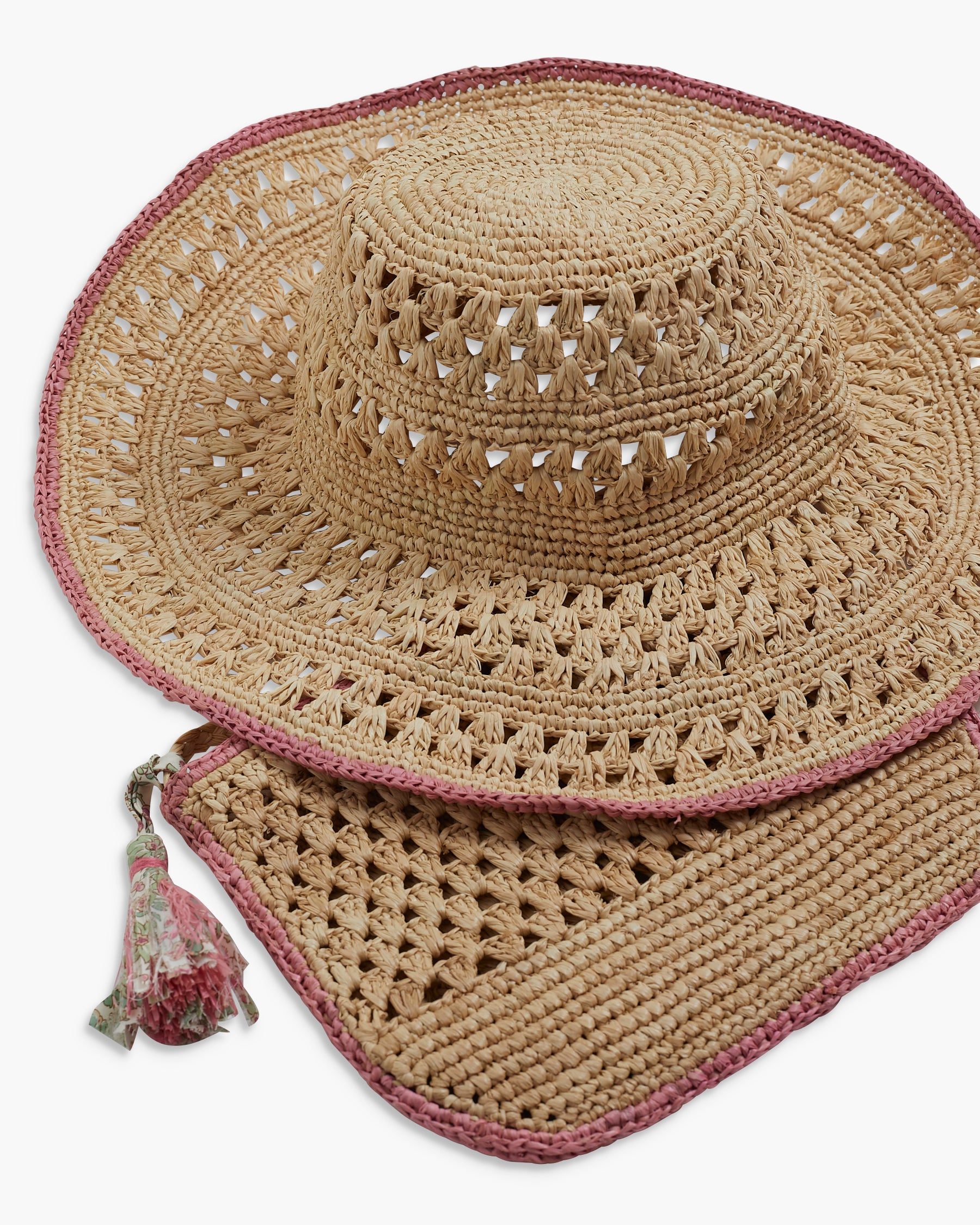 Beige straw hat with pink trim and tassel on a white background
