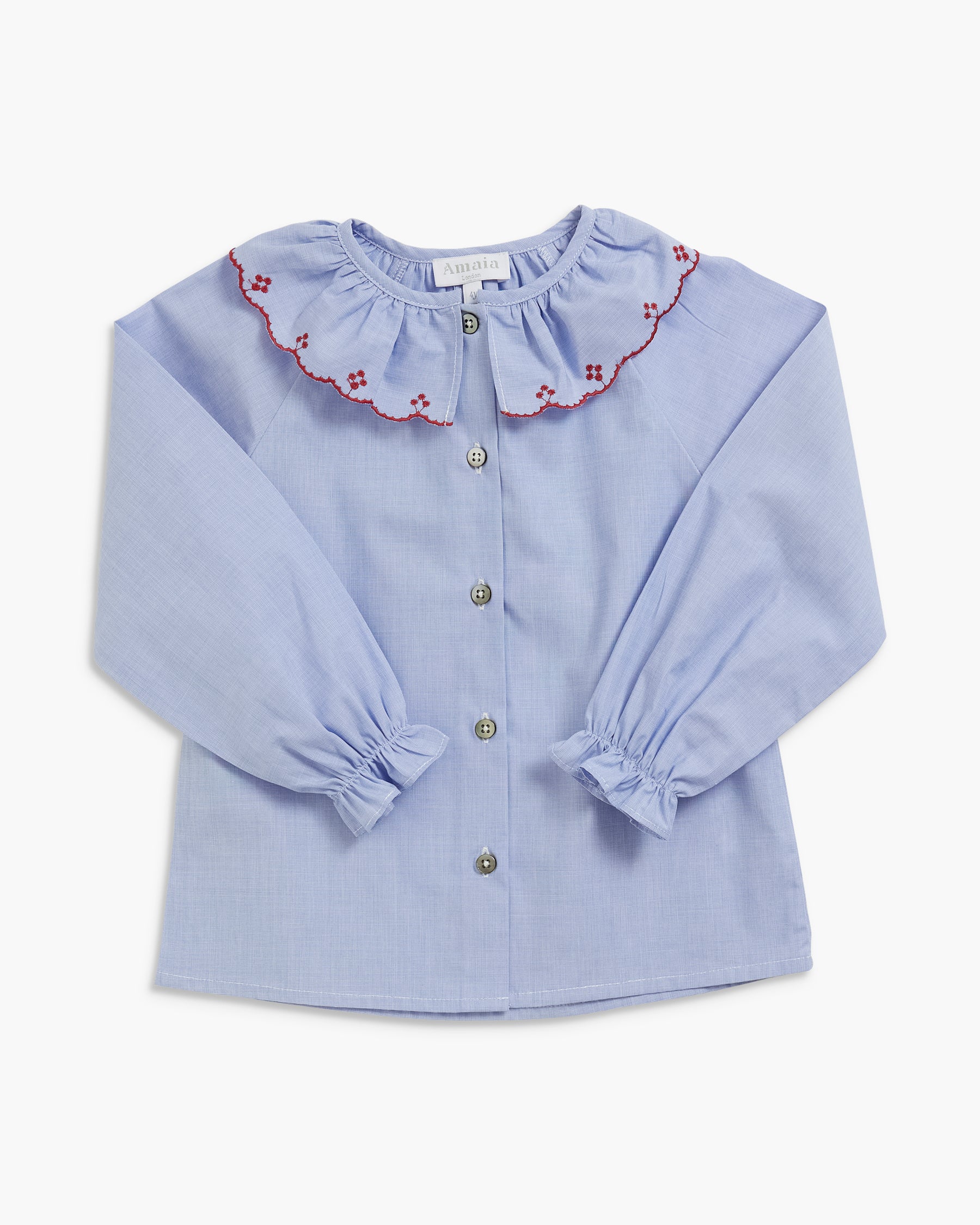 A light blue gingham long-sleeve blouse for a toddler girl, featuring a ruffled collar with red floral embroidery, button-front closure, and gathered cuffs.