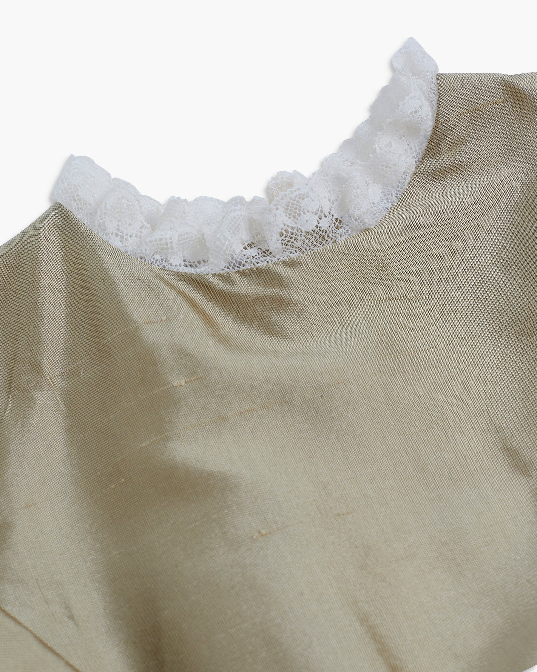 Beige top with lace trim on a white background