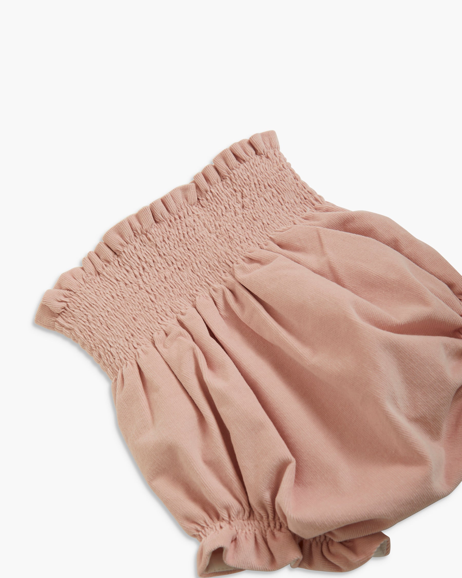 A dusty pink baby bloomers or diaper cover with a smocked elastic waistband and gathered ruffled leg openings, shown on a clean white background.