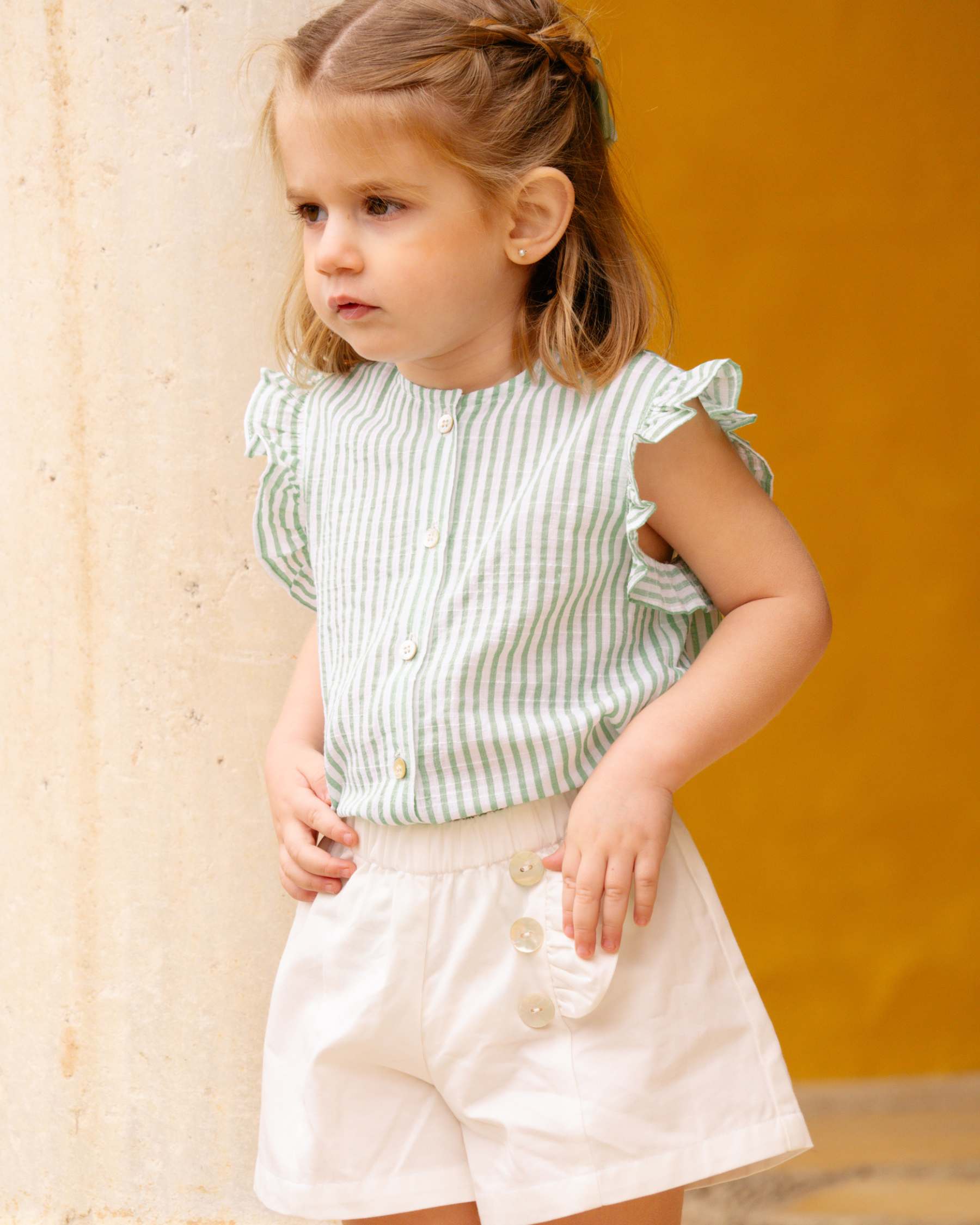 Young Girl is wearing the white shirt and stripy blouse