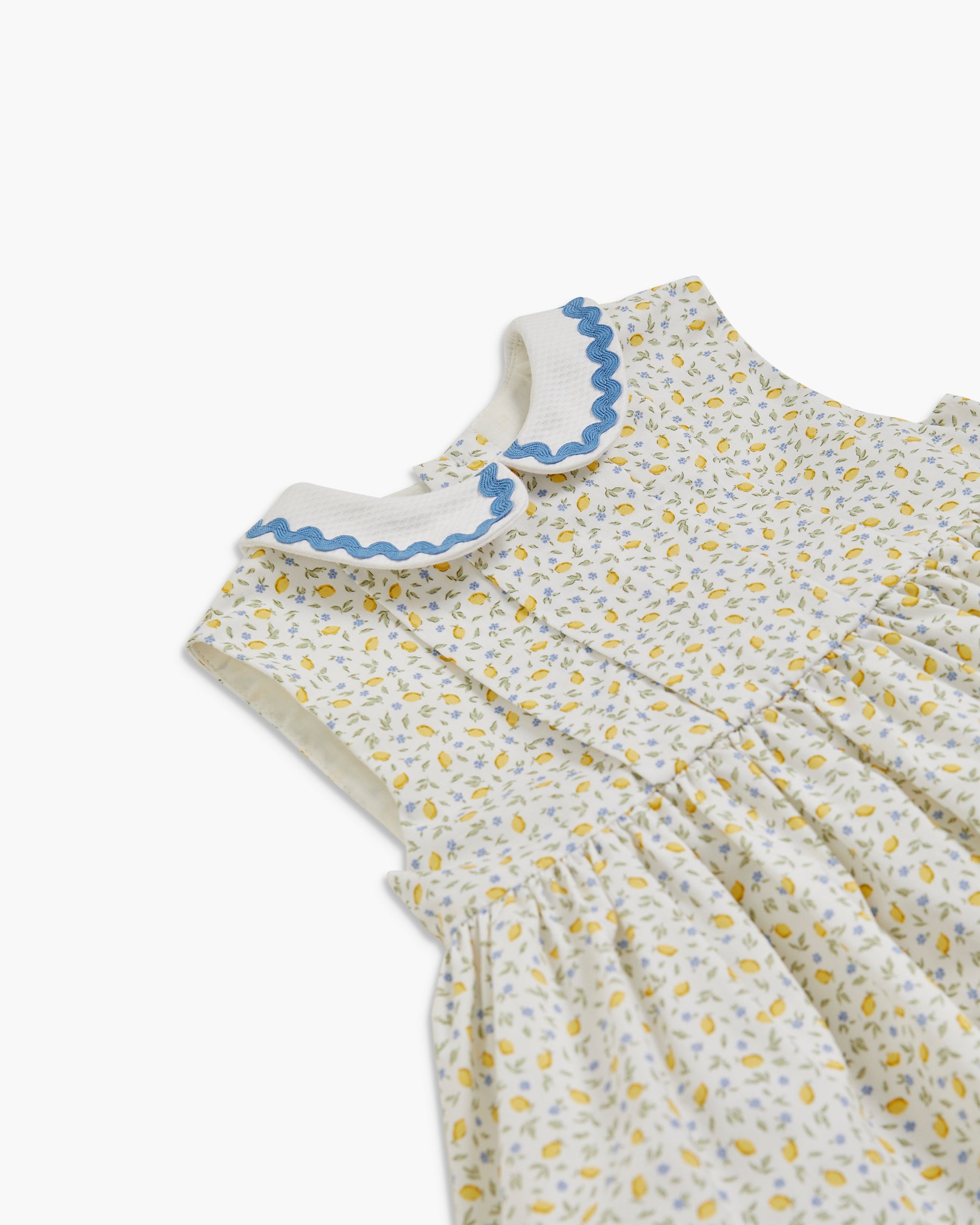 Children's dress with floral pattern and blue trim on a white background