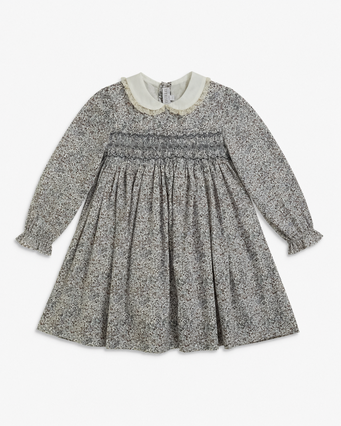 A long-sleeve children's dress with a gray and white speckled pattern, featuring a smocked bodice, ruffled cuffs, and a contrasting cream-colored Peter Pan collar.