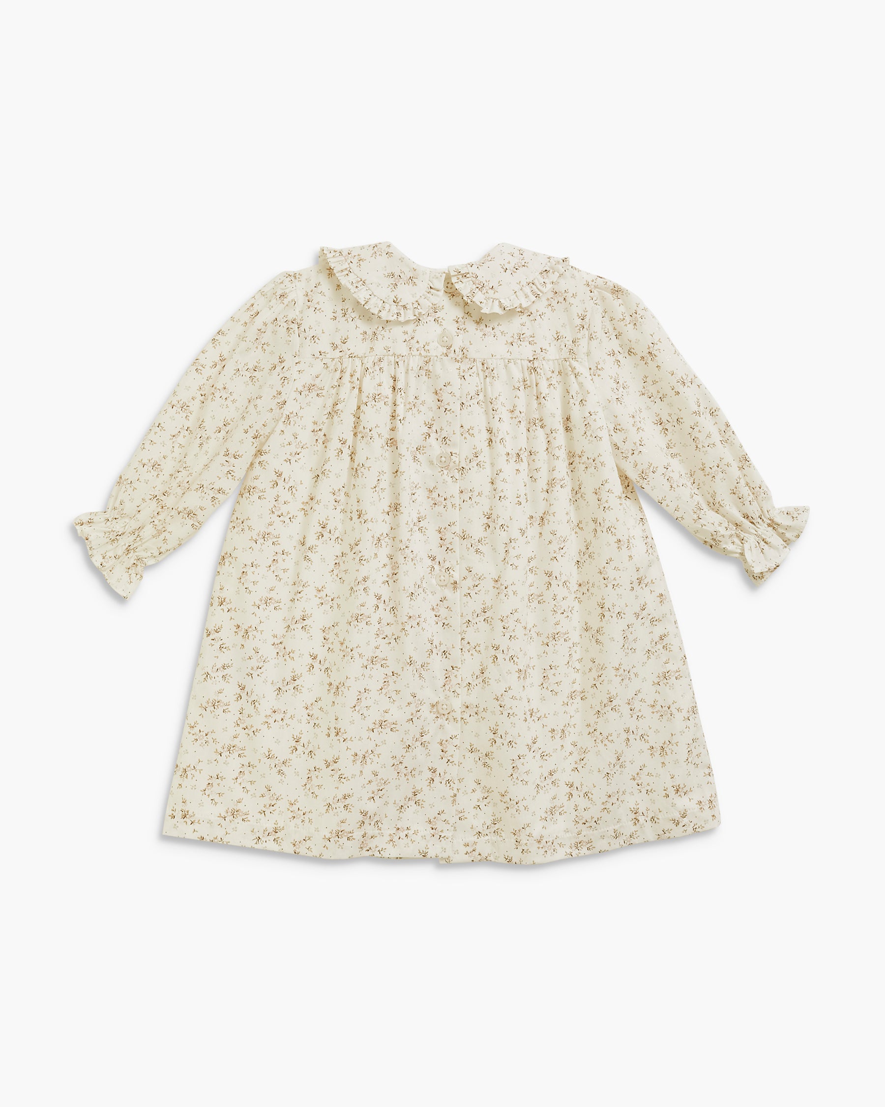 A long-sleeve baby dress in cream with a delicate all-over floral print, featuring a ruffled Peter Pan collar and ruffled cuffs, laid flat against a light gray background.