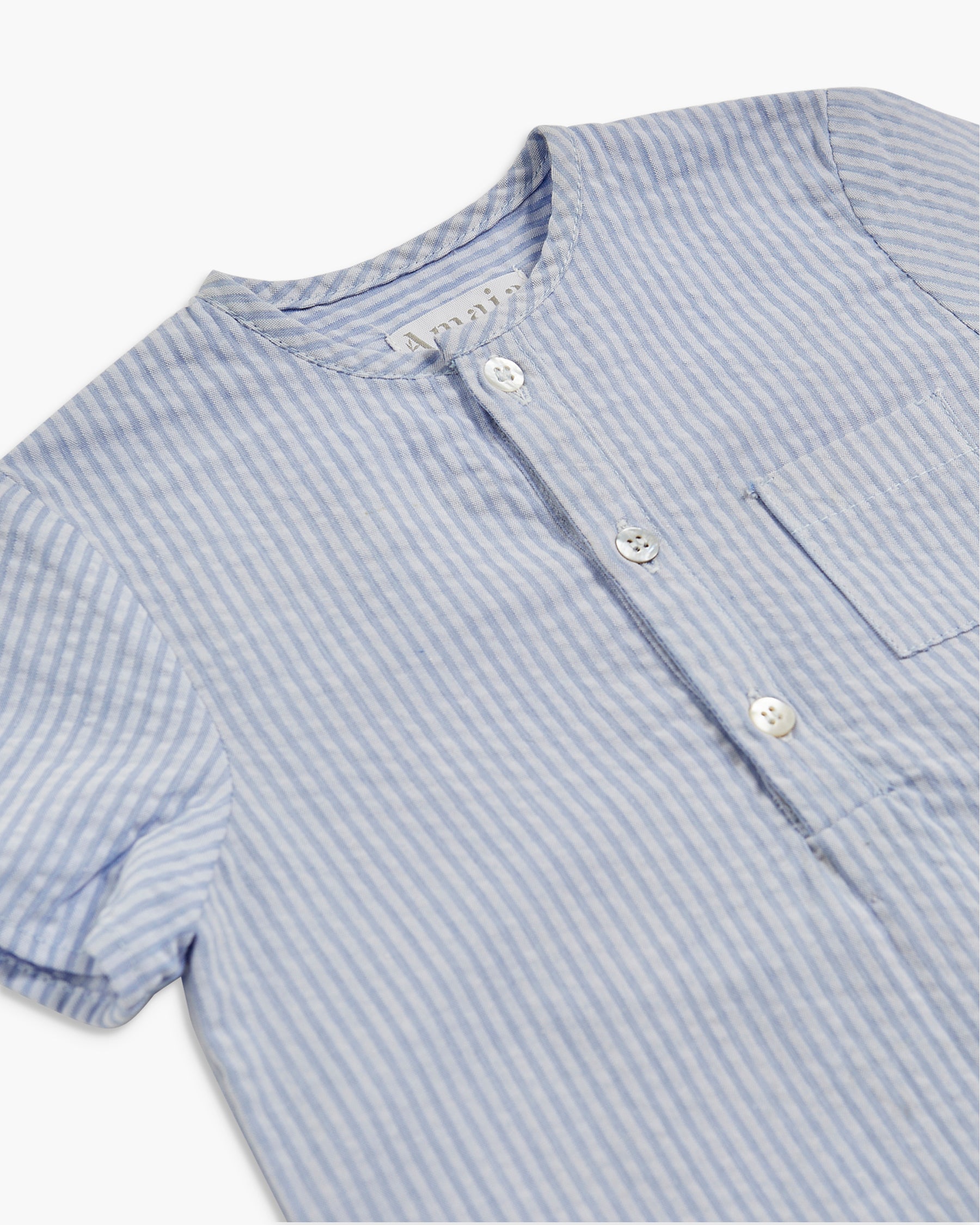 Close-up of a blue and white striped shirt with buttons on a white background